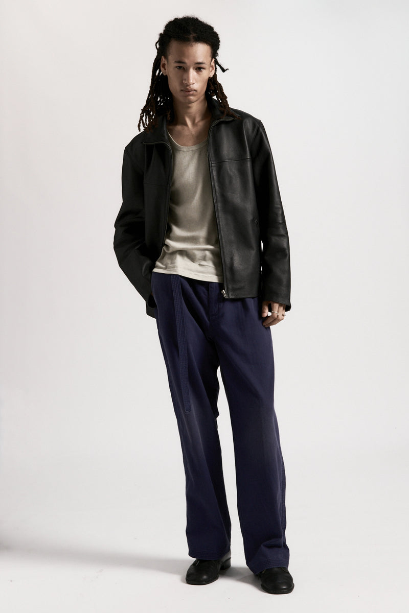 Person wearing the black leather Bank Jacket, white shirt and navy pants on a white background