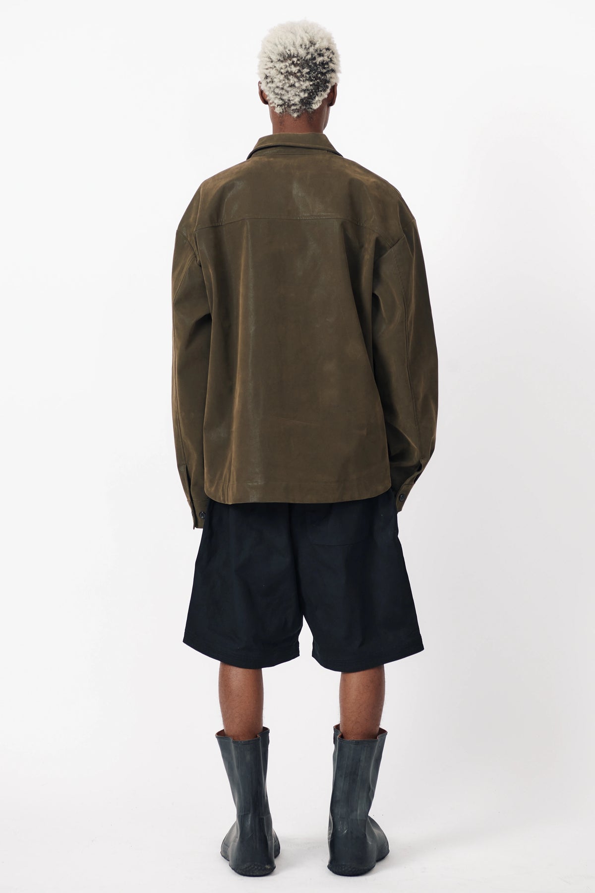 View from behind of a person standing facing the other way wearing a pair of Beach Brains black baggy shorts 