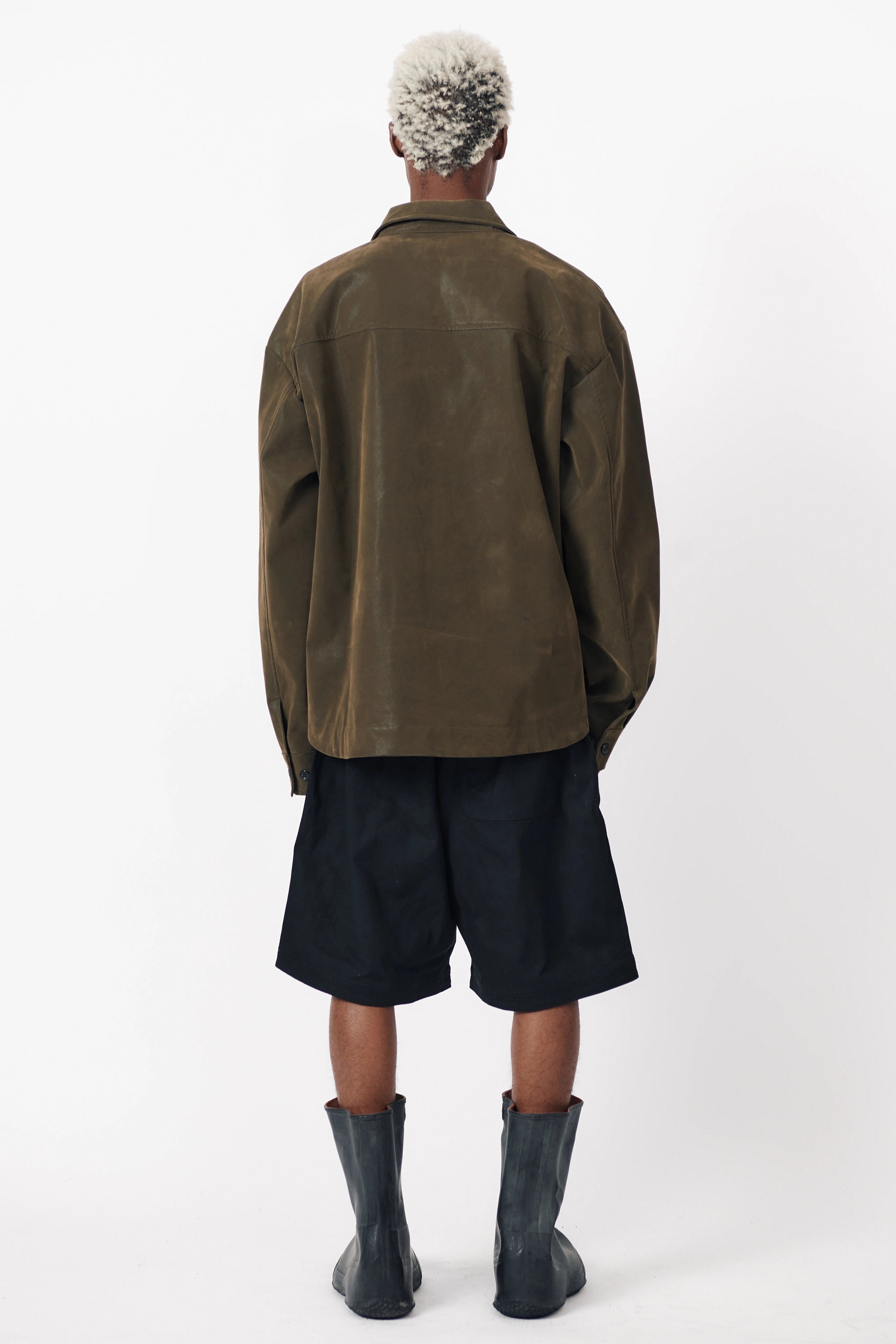 View from behind of a person standing facing the other way wearing a pair of Beach Brains black baggy shorts 