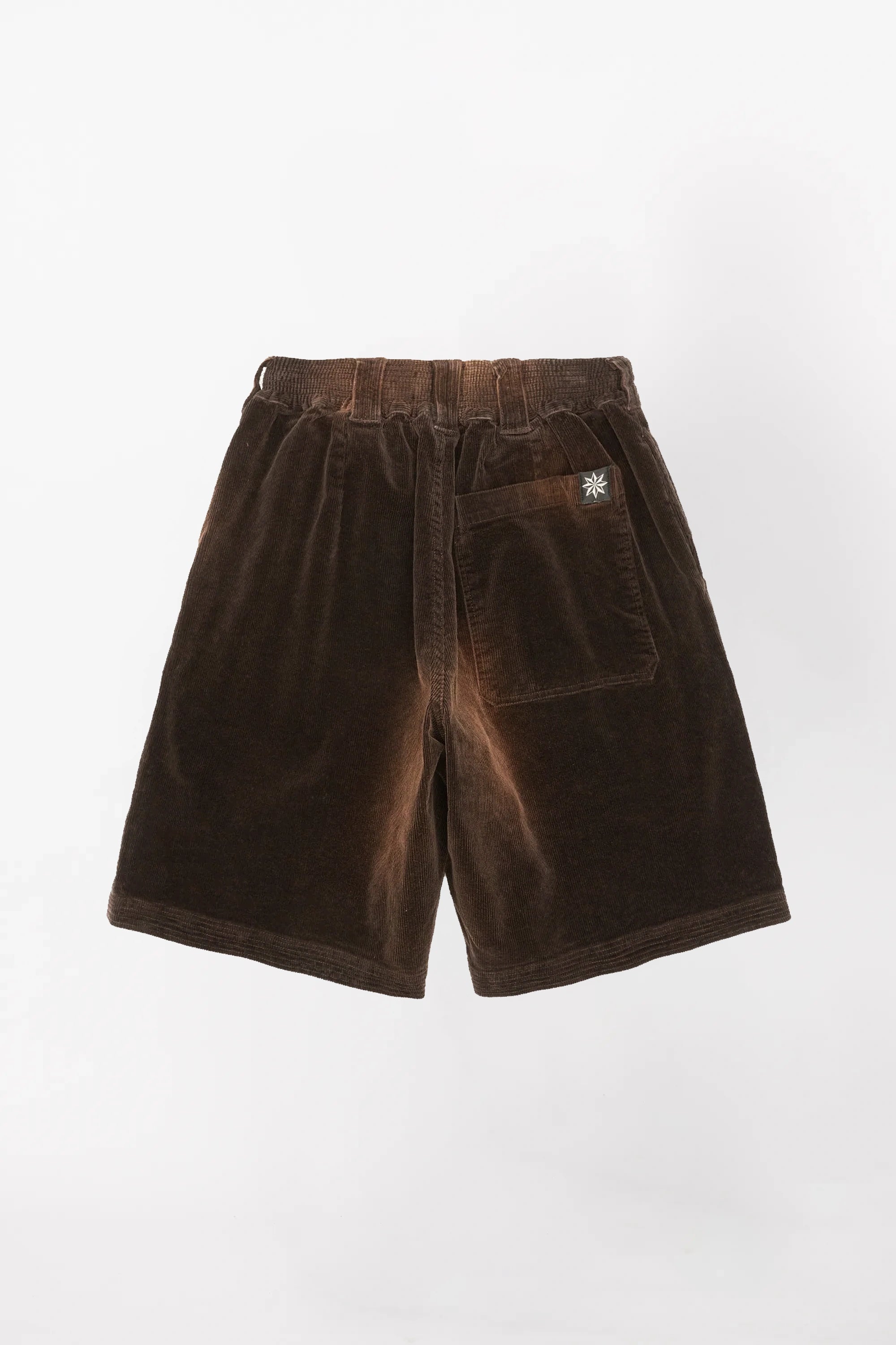 View from behind of a pair of brown corduroy baggy shorts  in a washed brown colour with an elastic waistband 