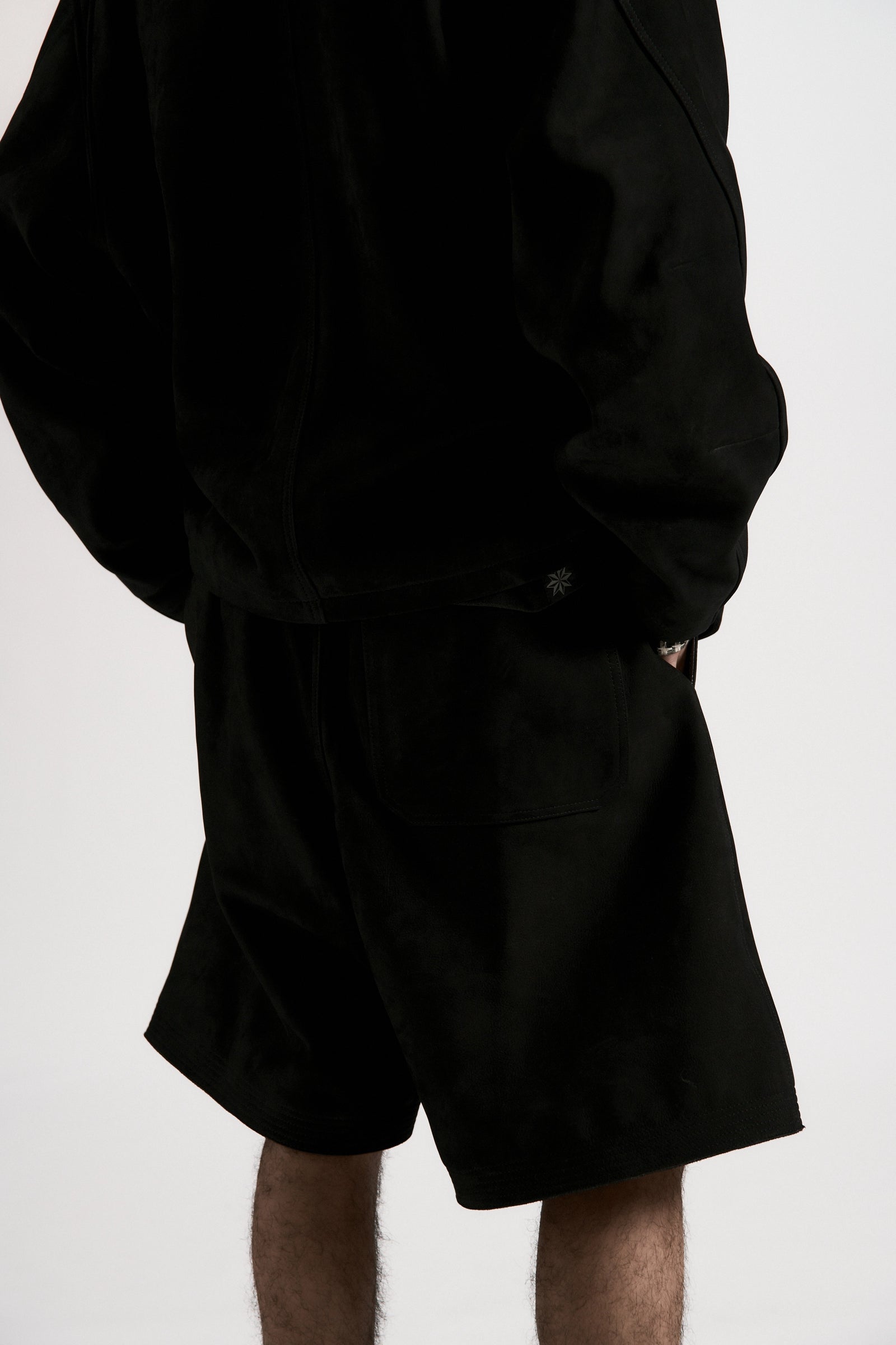 Person wearing a black shirt and shorts on a white background