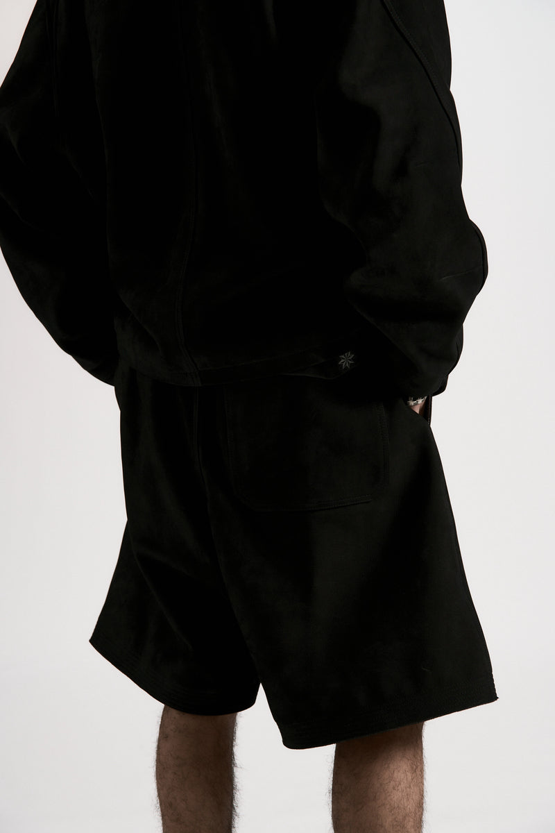 Person wearing a black shirt and shorts on a white background