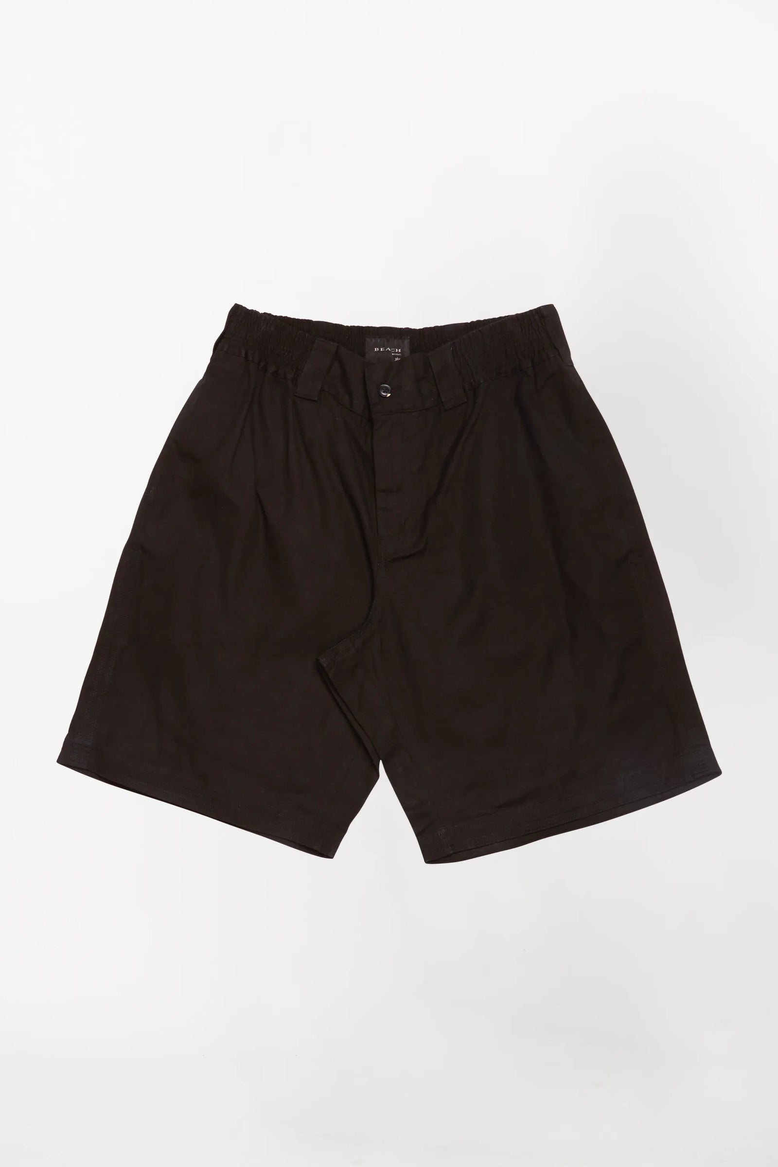 A pair of black baggy shorts designed by Beach Brains on top of a white background