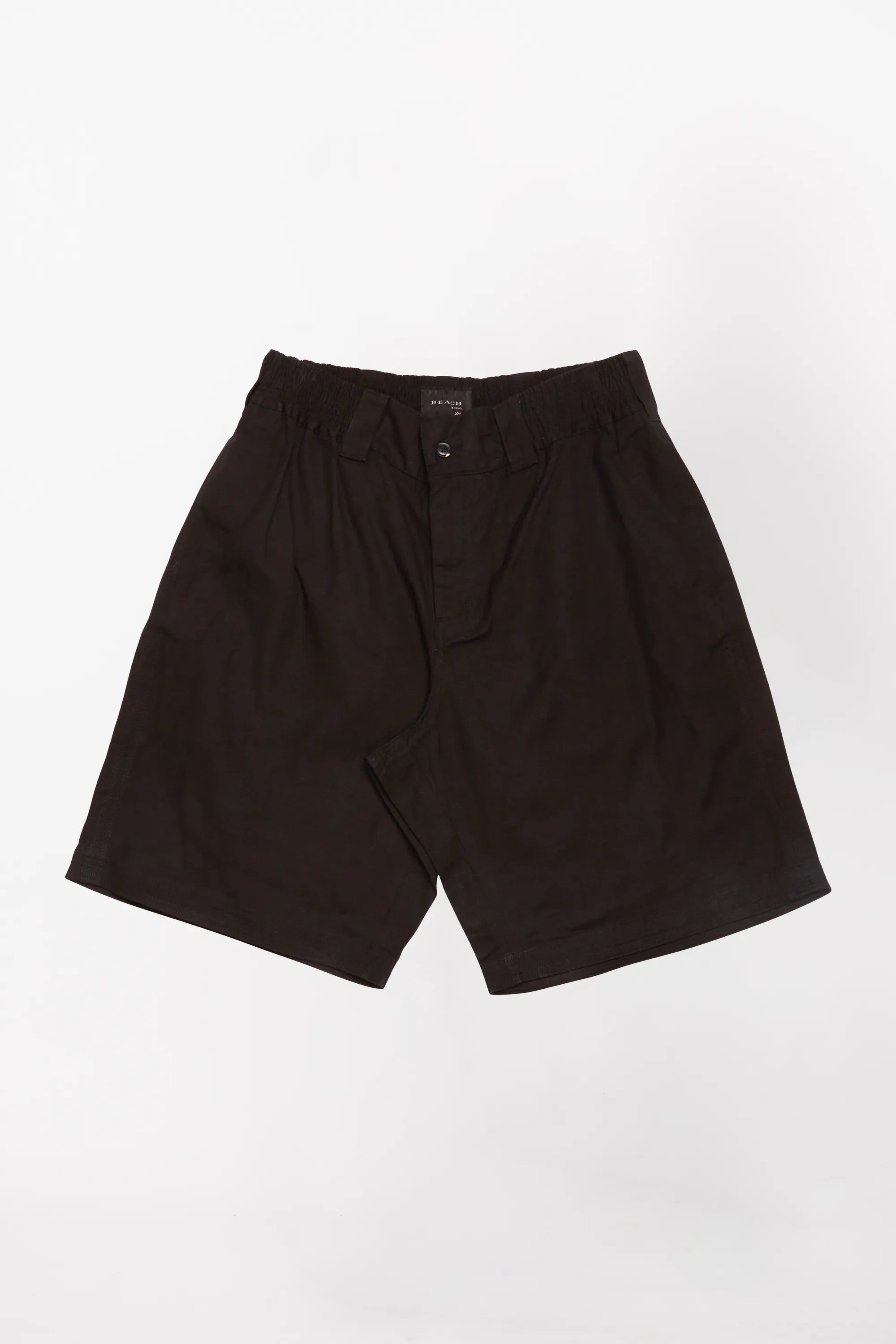 A pair of black baggy shorts designed by Beach Brains on top of a white background