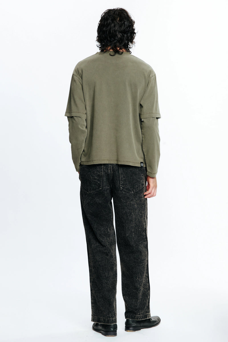 Person wearing a green shirt and dark jeans from behind on a white background