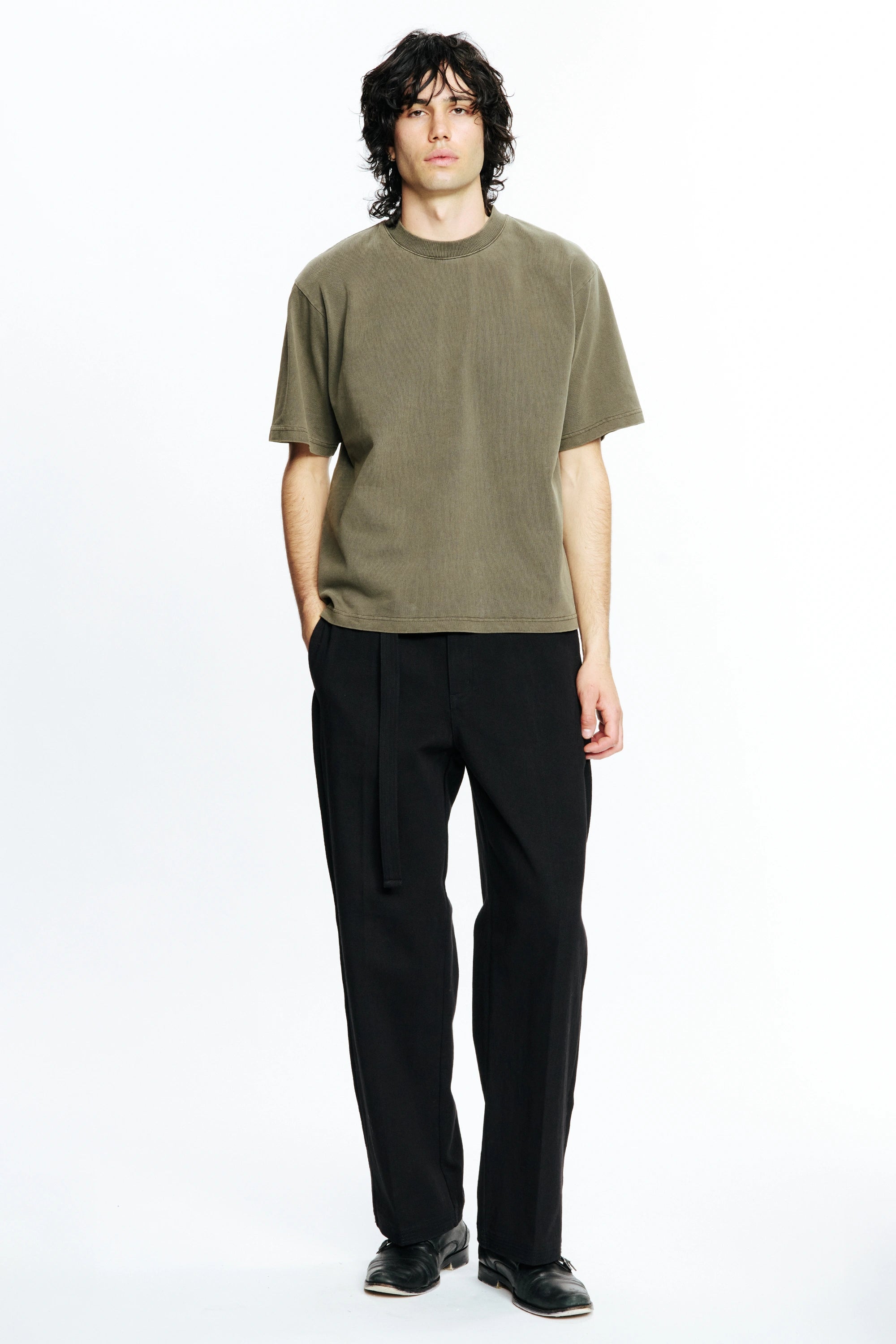 Person wearing a Fatigue Dream T-Shirt and black pants on a white background