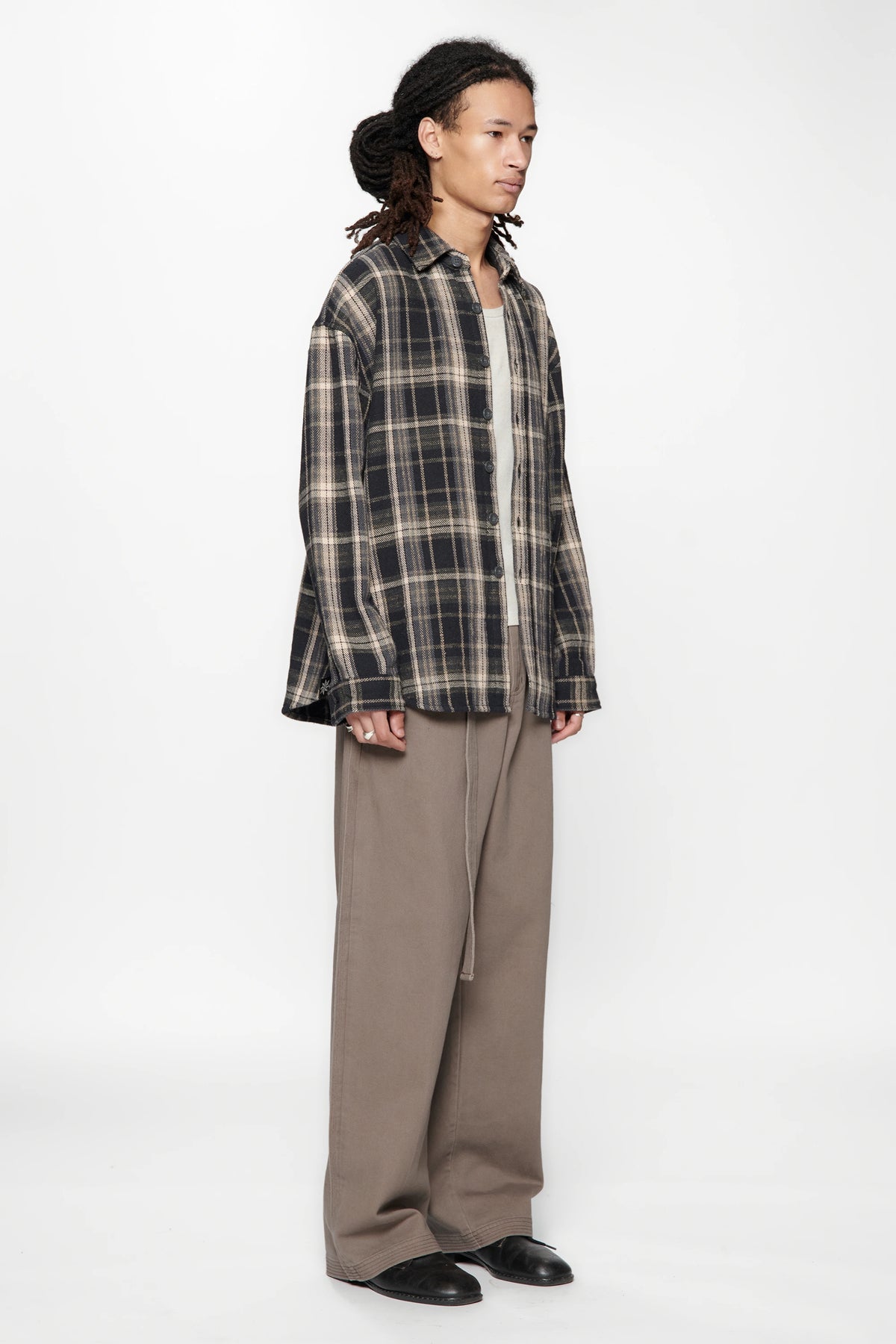 Person wearing a Navy Check Drop Long Sleeve Shirt and beige pants on a white background