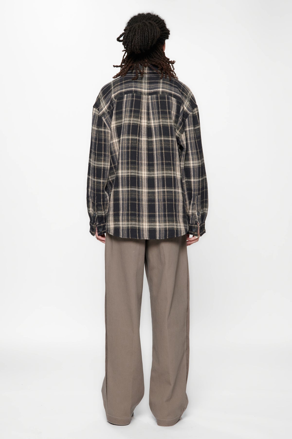 View from behind of a person wearing a Navy Check Drop Long Sleeve Shirt and beige pants on a white background