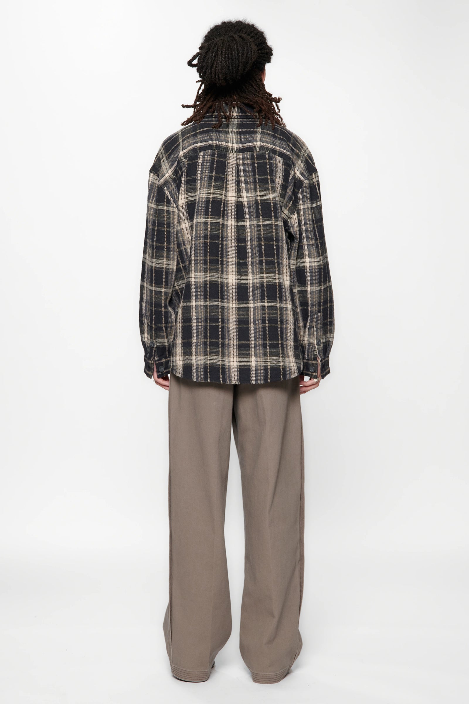 View from behind of a person wearing a Navy Check Drop Long Sleeve Shirt and beige pants on a white background