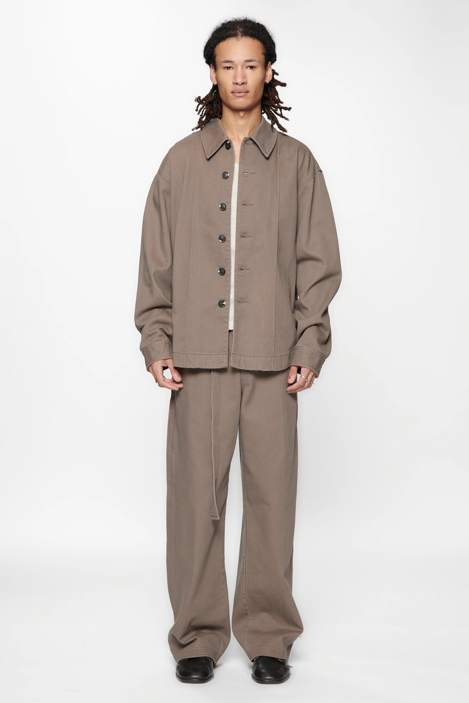 Person wearing a Gravel  Float Overshirt and beige pants set on a white background