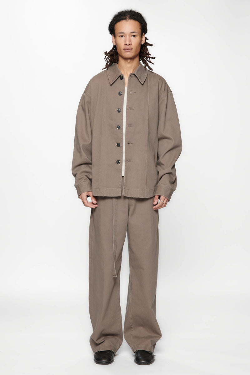 Person wearing a Gravel  Float Overshirt and beige pants set on a white background