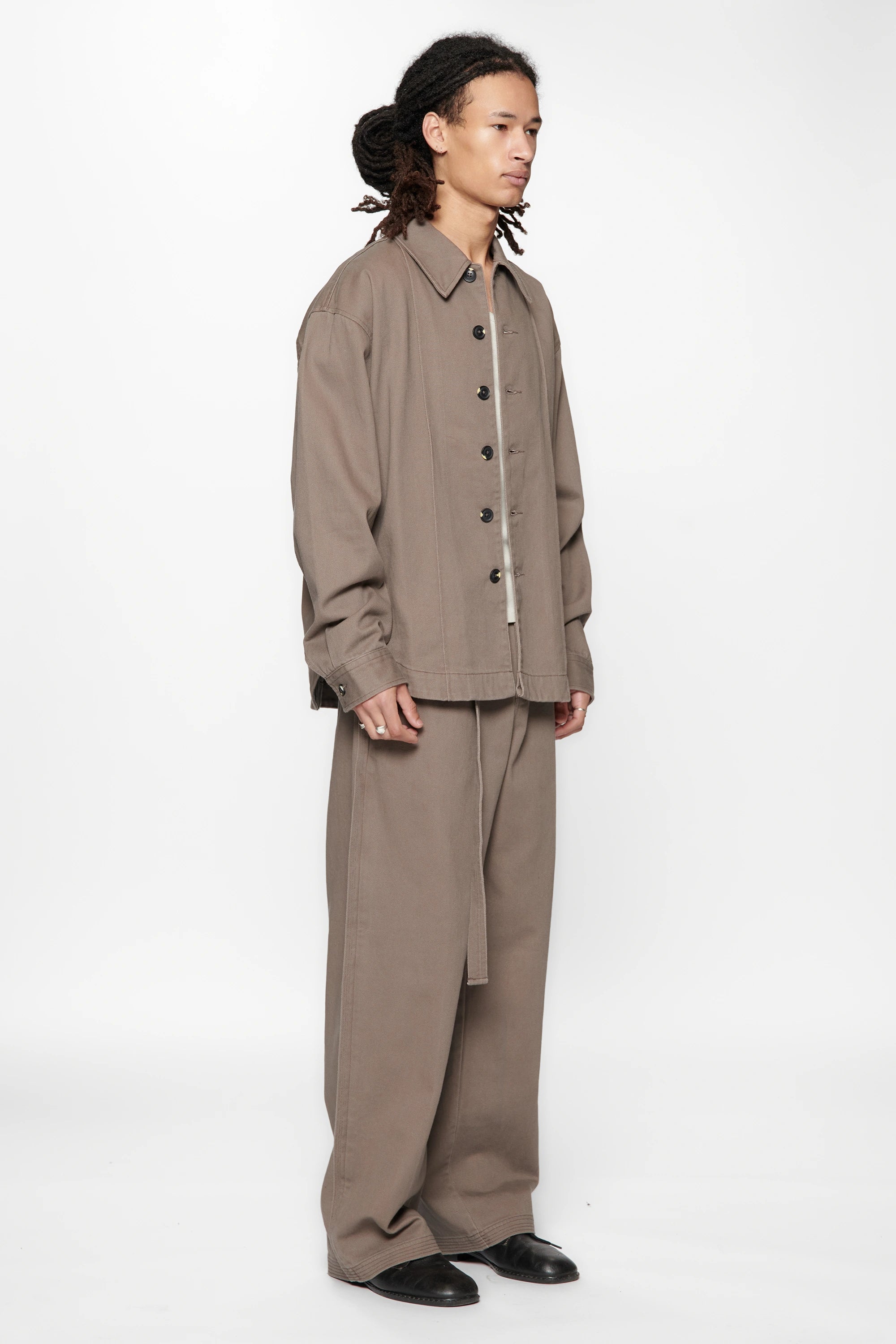 Person wearing a beige suit on a white background