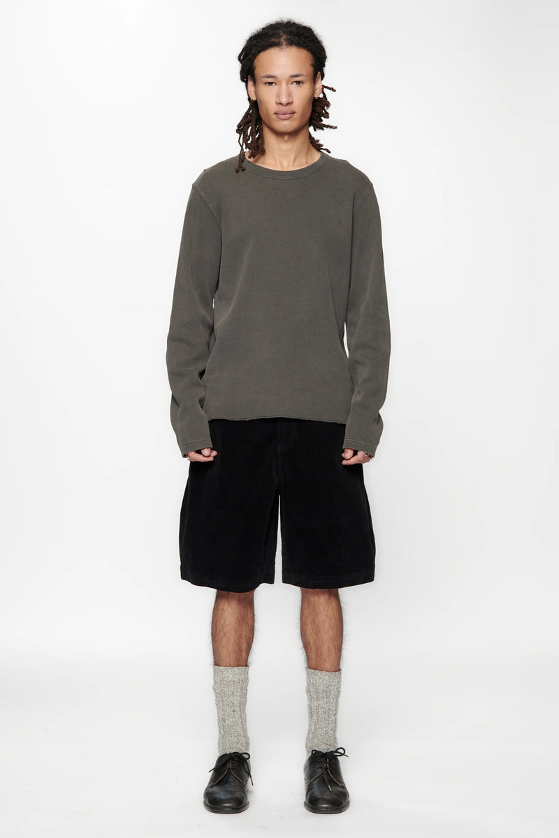 Person wearing a grey sweater and Vintage Black Corduroy Hang Shorts on a white background