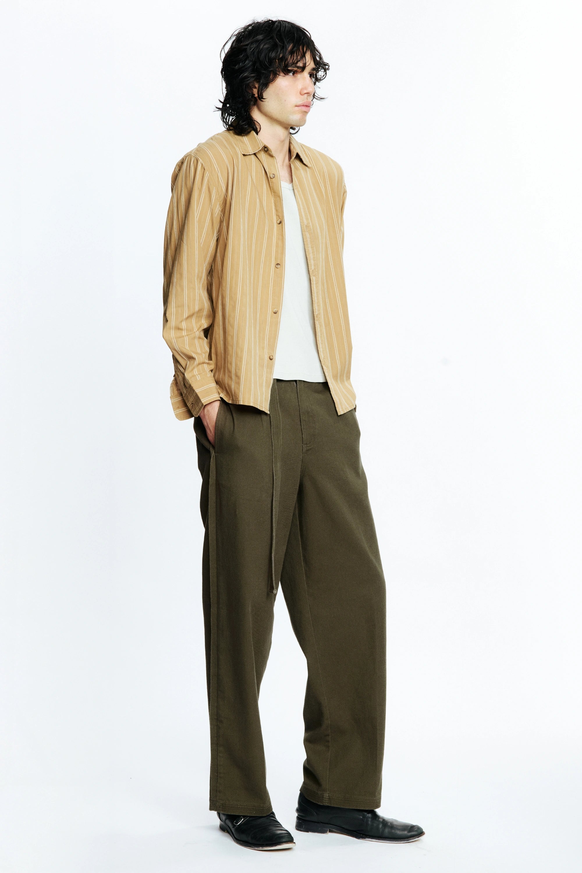 Person wearing a Tan Stripe Hold Long Sleeve Shirt and green pants on a white background