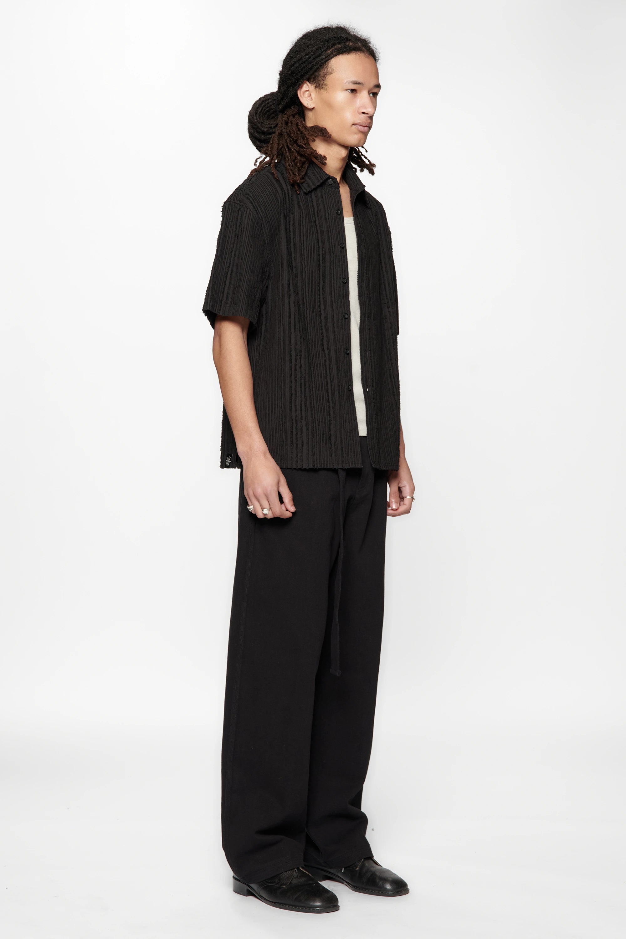 Side view of a person wearing the Hold SS Shirt in Black Tux on white background