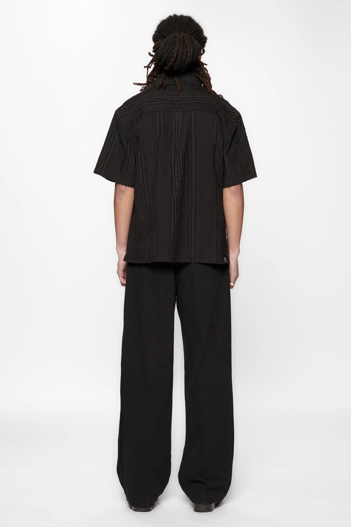 Behind view of a person wearing the Hold SS Shirt in Black Tux on white background
