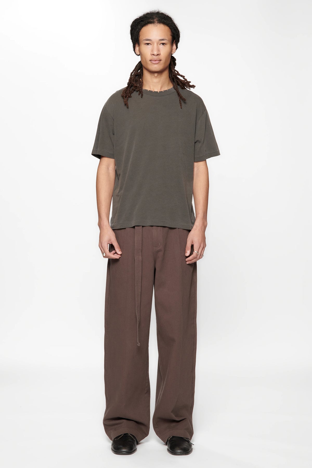 Person wearing the Dark Grey Pleated Work Pants by Beach Brains on a white background
