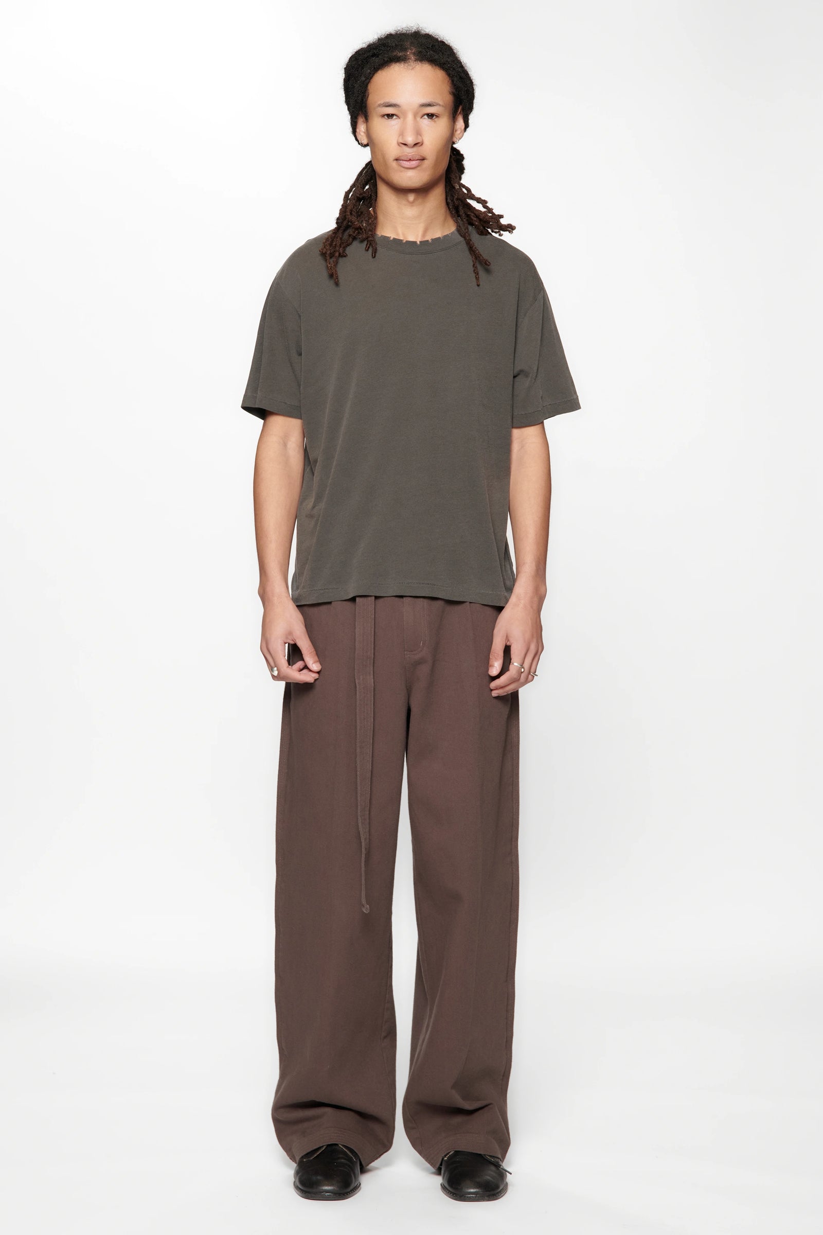 Person wearing the Dark Grey Pleated Work Pants by Beach Brains on a white background