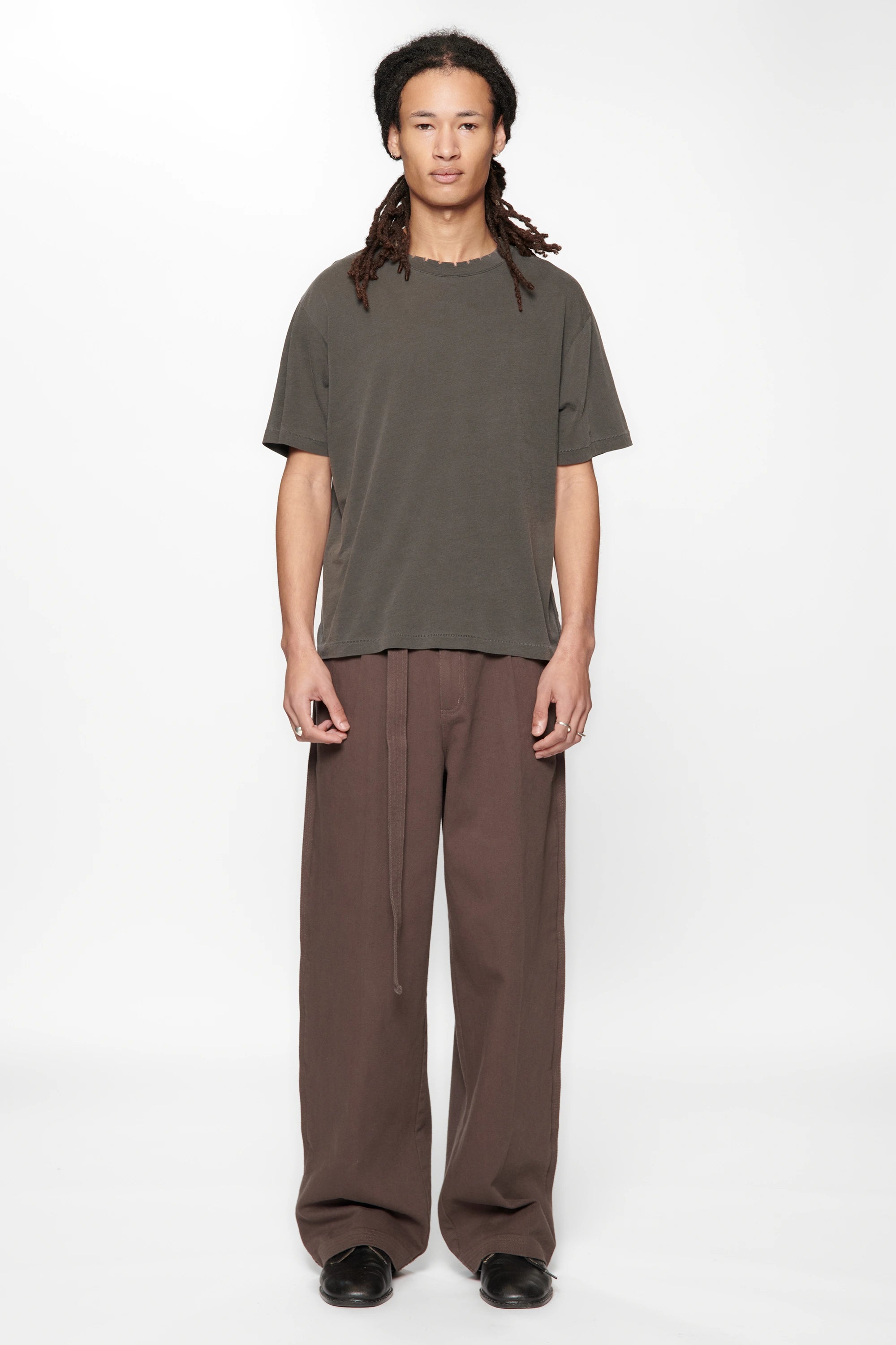 Person wearing the Dark Grey Pleated Work Pants by Beach Brains on a white background