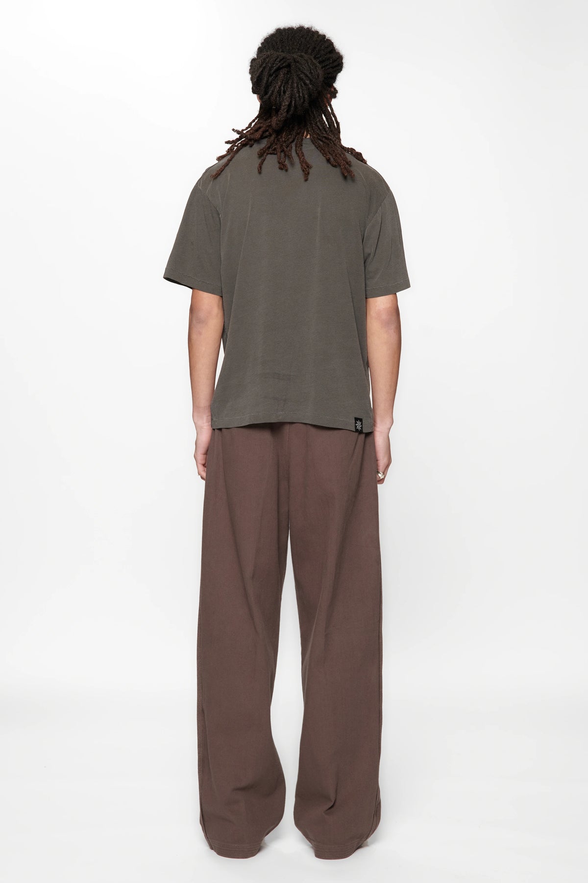 Rear view of a male wearing  the Dark Grey Pleated Work Pants by Beach Brains