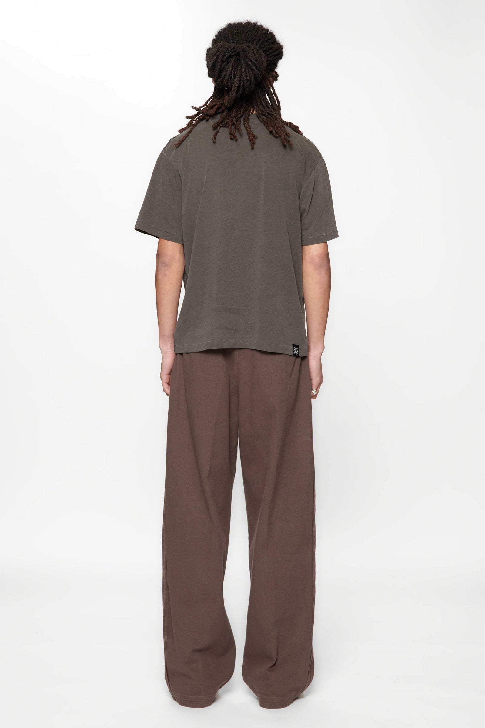 Rear view of a male wearing  the Dark Grey Pleated Work Pants by Beach Brains