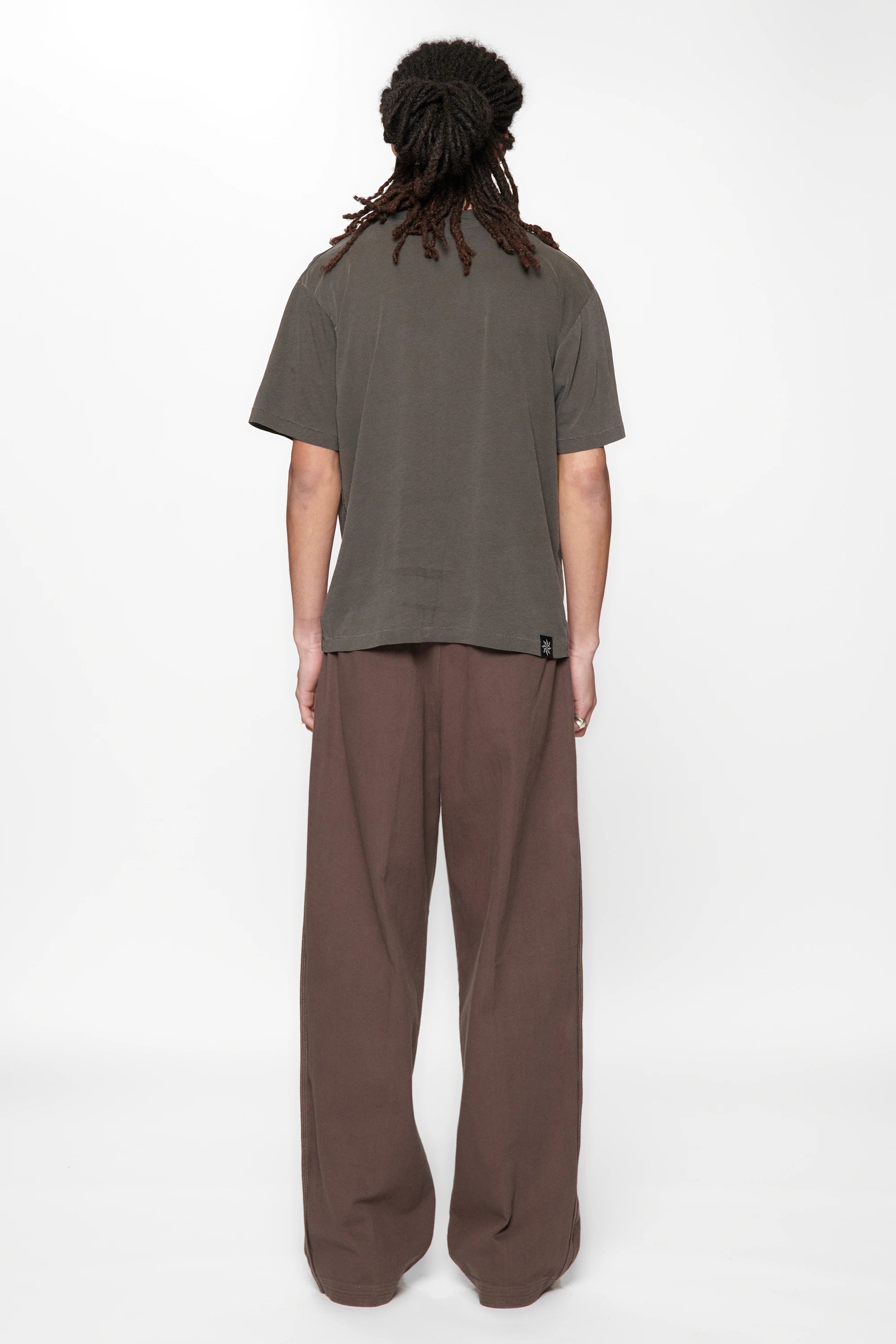 Rear view of a male wearing  the Dark Grey Pleated Work Pants by Beach Brains