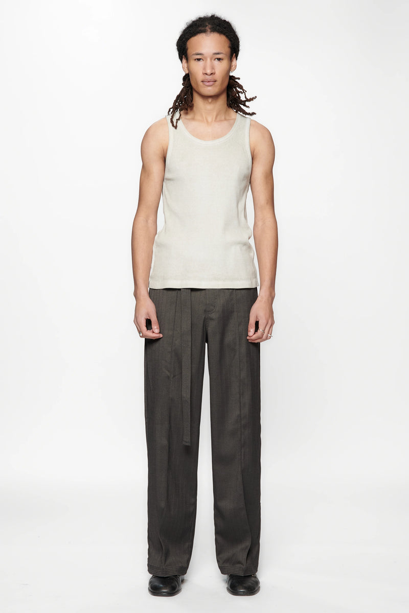 Person wearing a light-colored sleeveless top and the Shadow Suit Pants Black Herringbone by Beach Brains